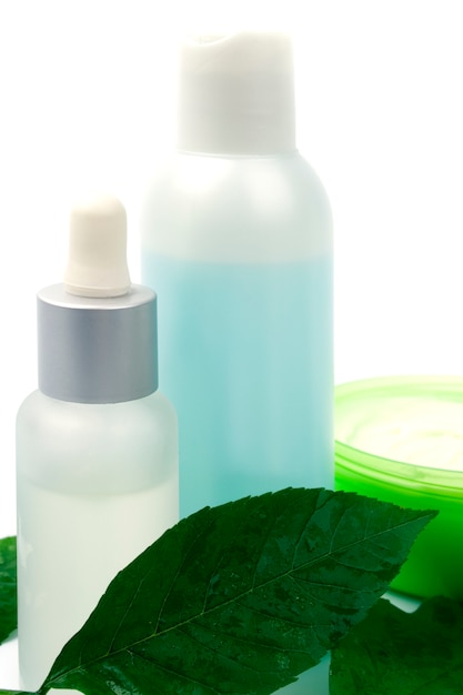 Productos cosméticos con hoja verde sobre fondo blanco