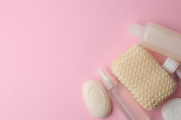 Productos para el cuidado del cuerpo y la piel en envases blancos sobre un delicado fondo rosa. Productos de higiene personal. Vista desde arriba. con espacio para texto