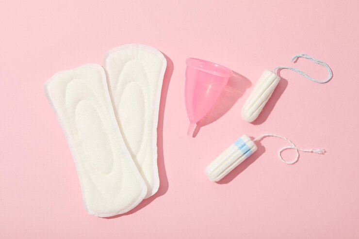 Productos de higiene femenina menstrual sobre fondo rosa.