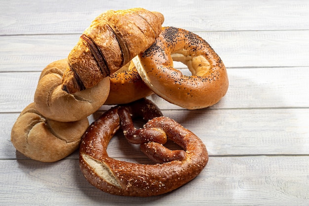 Productos horneados con levadura dulce. Rosquillas, rosquillas, croissants, pretzels. Sobre un fondo claro. Copie el espacio.