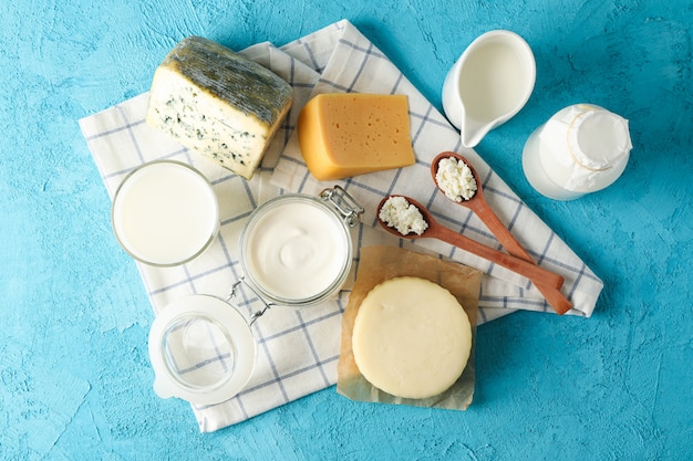 Productos lácteos frescos y papel de cocina sobre fondo azul.