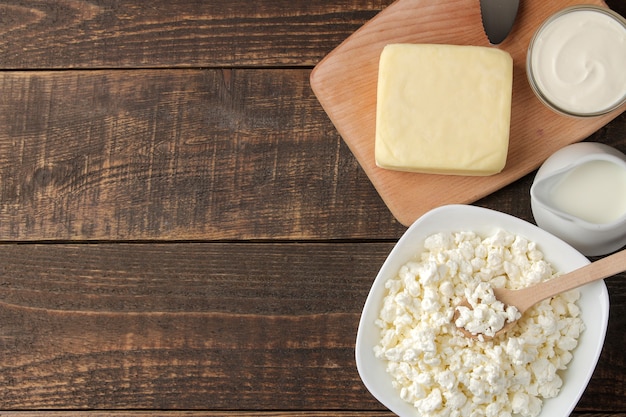 Productos lacteos. Leche, crema agria, queso, mantequilla y requesón en una mesa de madera marrón. vista superior. marco. espacio para texto