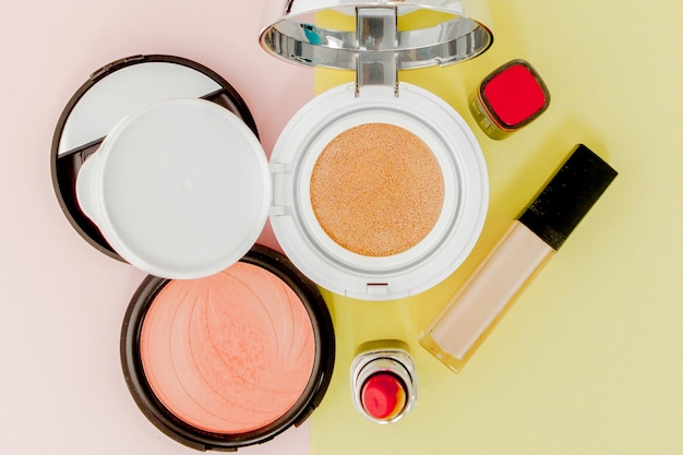 Los productos de maquillaje se derraman en un color amarillo brillante y rosa