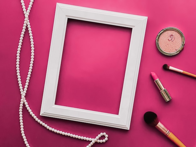 Productos de maquillaje de marco de arte vertical blanco y joyas de perlas sobre fondo rosa como impresión de arte de diseño plano o álbum de fotos