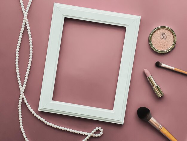 Foto productos de maquillaje de marco vertical y joyas de perlas sobre fondo rosa ruborizado como impresión de arte de diseño plano o álbum de fotos