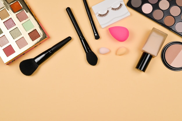 Productos de maquillaje profesionales de moda con productos cosméticos de belleza, base, lápiz labial, sombras de ojos, pestañas, cepillos y herramientas.