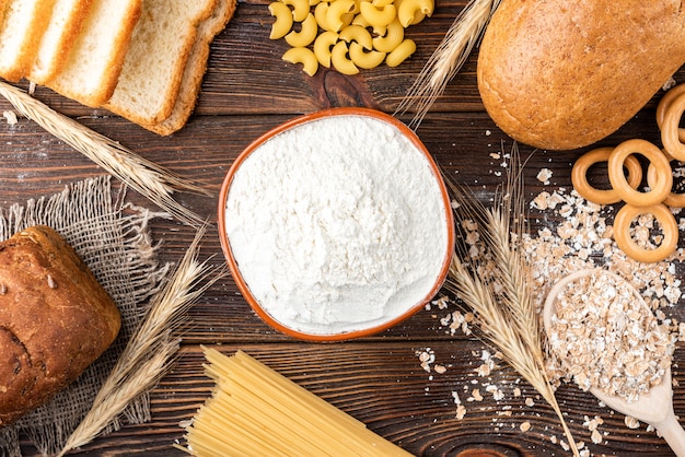 Foto productos de panadería y pasta en madera oscura.