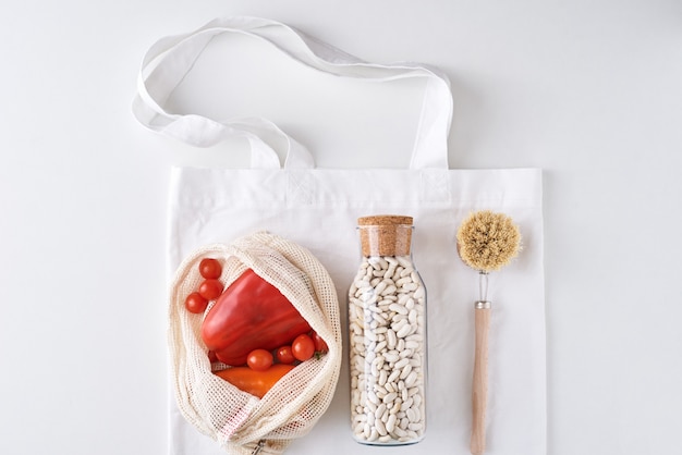 Foto productos reutilizables libres de plástico, concepto de cero residuos. verduras frescas, frijoles en una botella de vidrio y bolsa de compras textil