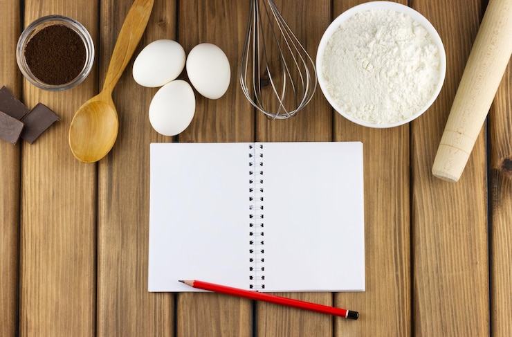 Foto productos y utensilios de cocina para cocinar con bloc de notas en blanco.