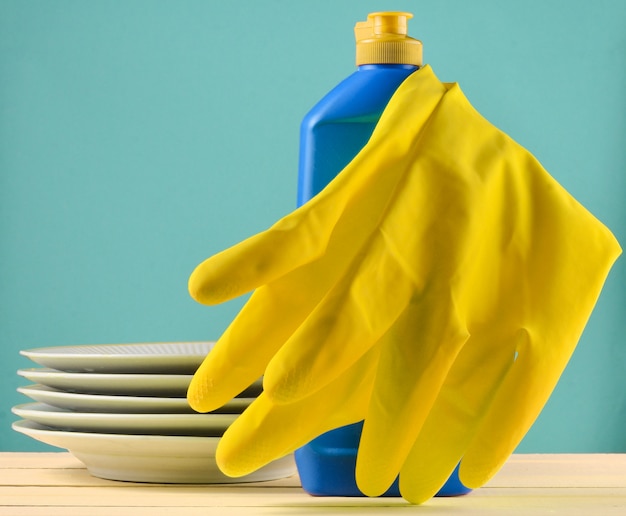 Produkte zum Abwaschen von Geschirr auf einem Tisch lokalisiert auf einem blauen Pastellhintergrund