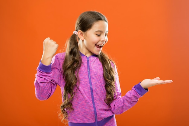 Produktpräsentation Kid Happy Face zeigt etwas auf offenem Handflächenkopierraum Mädchen demonstriert Produkt Werbung und kommerzielles Konzept Produktförderung für Kinder Produkteinführung für Kinder