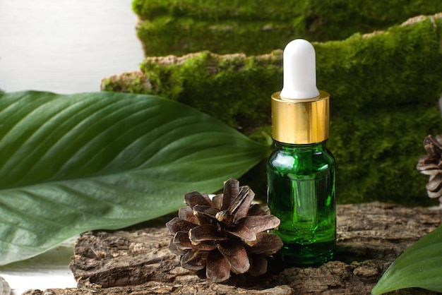 Produto cosmético ecológico em frasco de vidro com vitaminas de aloe de óleos para mentiras saudáveis em musgo florestal natural