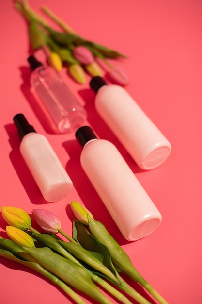 Produto de garrafas de maquiagem cosmética de beleza com conceito de cuidados com a pele em fundo rosa