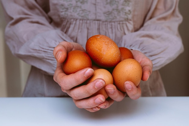 Produto natural da fazenda. mulher detém grandes ovos de galinha nas palmas das mãos. Ovos de galinha produzidos