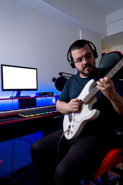 Produtor de rock masculino gravando a guitarra em casa