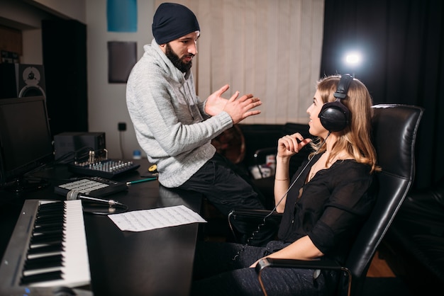 Produtor de som com cantora em estúdio musical