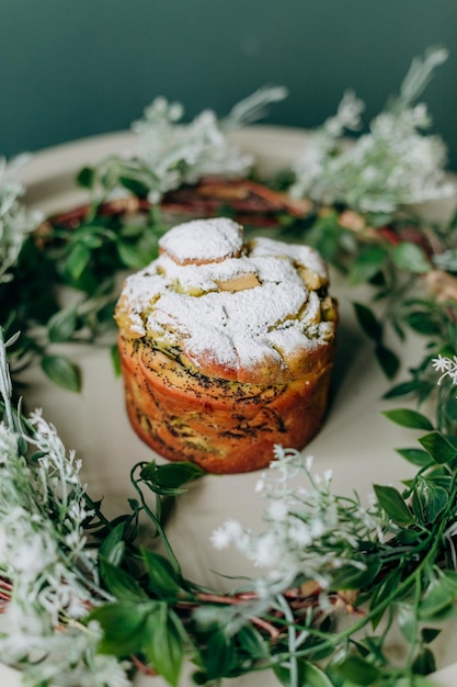 Produtos assados de Páscoa cheios de sementes de papoula e passas e polvilhados com pó com decoração de primavera