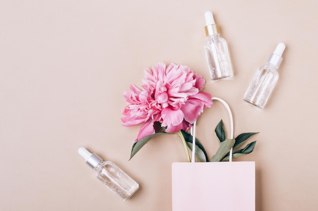 Produtos cosméticos de gel líquido e peônia rosa em saco de papel Conceito de cuidados com a pele de beleza