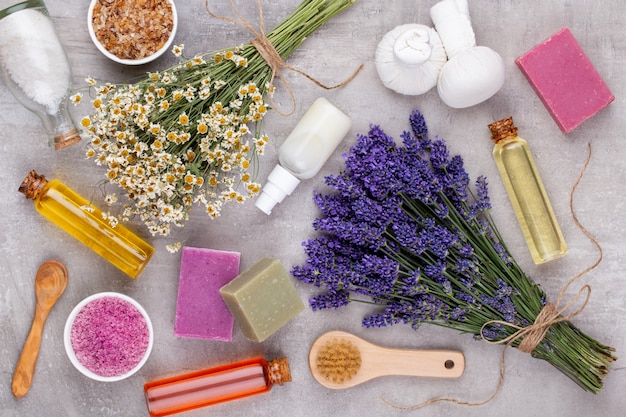 Produtos de aliciamento e buquê de lavanda fresca na mesa de madeira branca.