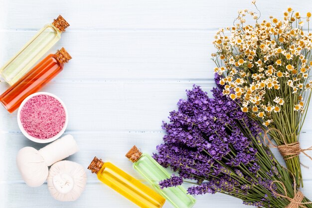 Produtos de aliciamento e buquê de lavanda fresca no fundo da mesa de madeira branca.