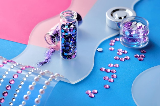 Produtos de glitter colorido neon em fundo cintilante rosa Fechamento em frascos de frascos com vários glitters em tons de azul rosa e turquesa