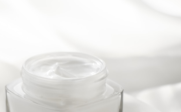 Produtos de higiene pessoal de marca cosmética e frasco de creme hidratante facial conceito spf em fundo de seda loção hidratante para a pele e cosméticos antiidade de emulsão de levantamento para marcas de beleza de luxo para a pele