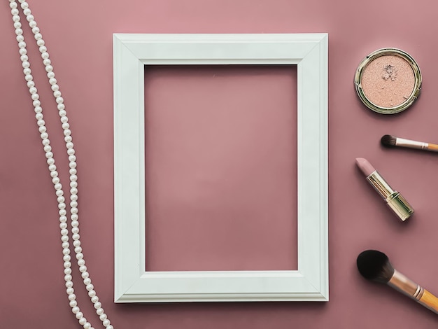 Produtos de maquiagem de moldura vertical e joias de pérola em fundo rosa blush como impressão de arte de design flatlay ou álbum de fotos