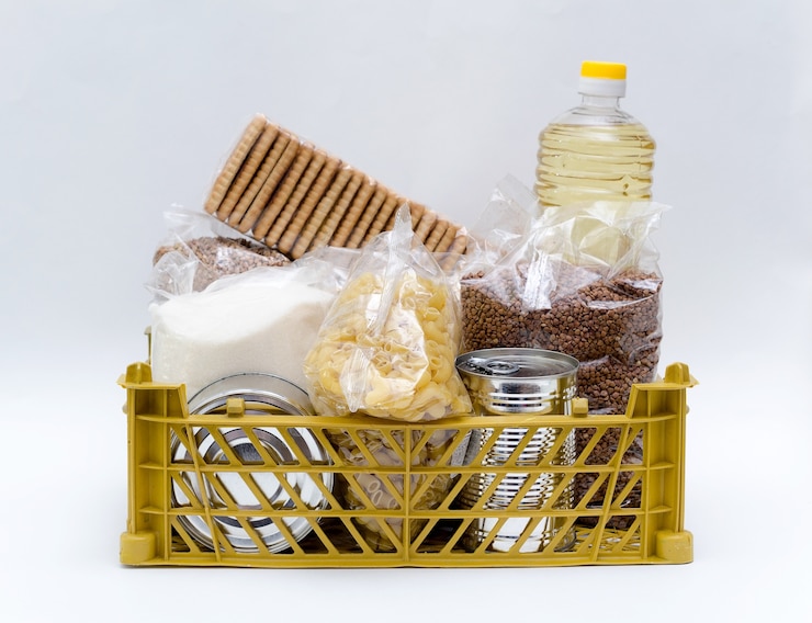 Foto produtos em pacotes de açúcar, trigo sarraceno, macarrão, óleo em uma garrafa em uma caixa estão em um branco