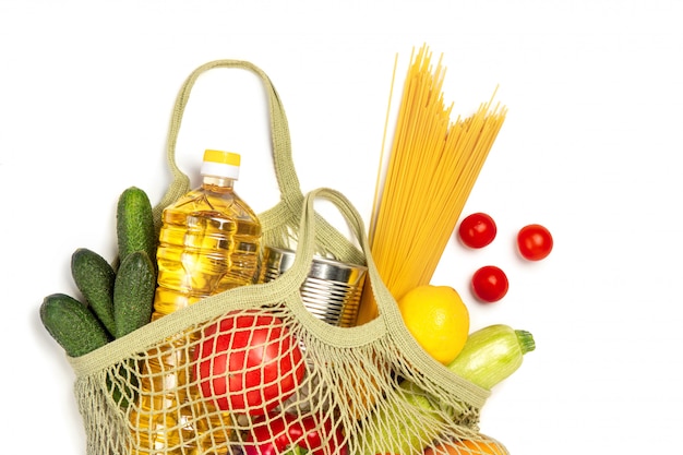 Foto produtos em um saco de corda em um fundo branco e isolado. o conceito de compras verdes e boa nutrição. entrega de produtos.