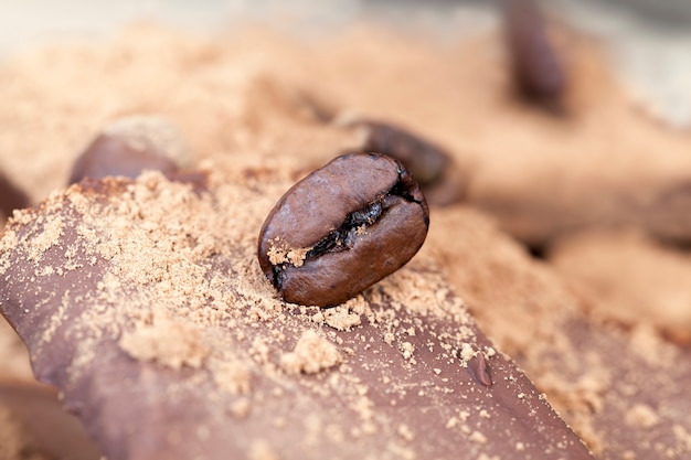 Produtos feitos de cacau e açúcar junto com ingredientes - cacau e café, quebrados em pedaços barra de chocolate doce com uma pitada de cacau e grãos de café