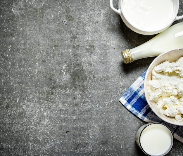 Produtos lácteos creme de leite, leite e queijo cottage no guardanapo na mesa de pedra