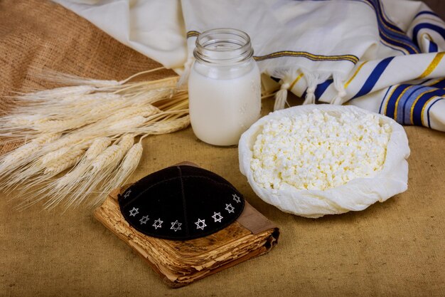 Produtos lácteos na mesa de campo de trigo símbolos de torá do feriado judaico shavuot