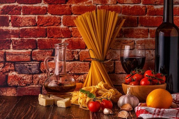 Foto produtos para cozinhar macarrão, tomate, alho, azeite e vinho tinto
