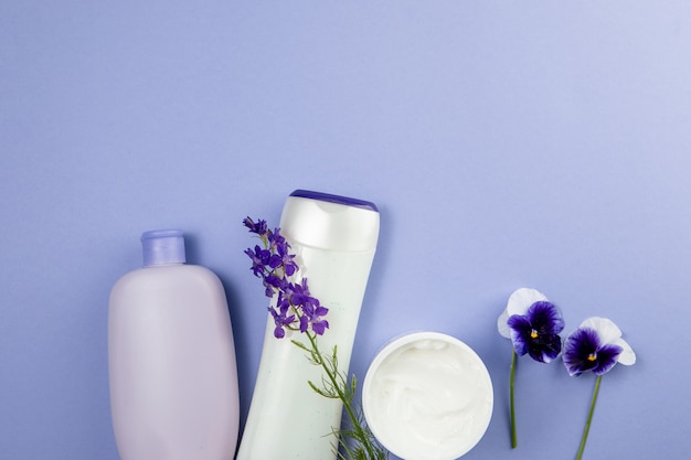 Produtos para cuidados com o corpo e flores em azul