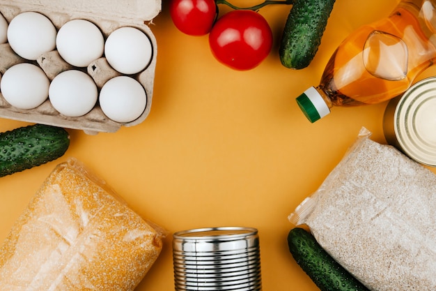 Foto produtos para doação em um fundo amarelo. legumes, cereais e alimentos enlatados. doações de alimentos copiam o espaço.