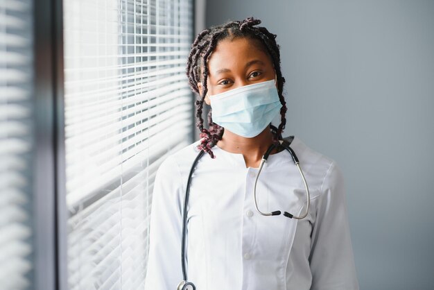 Profesión de medicina y concepto de atención médica cerca de una doctora o científica africana con máscara facial protectora