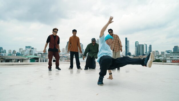 Profesionado en breakdance, practica bboy con amigos en el techo.