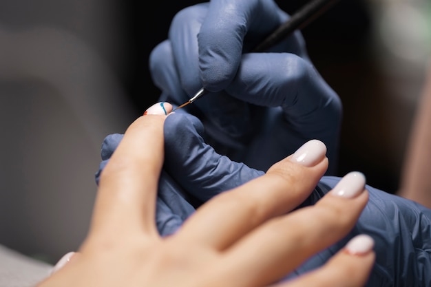 Foto profesional del arte de las uñas trabajando en las uñas de los clientes