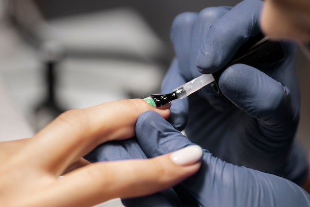 Foto profesional del arte de las uñas trabajando en las uñas de los clientes