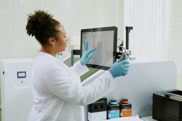 Profesional médico interactuando con un gran monitor de pantalla táctil en una clínica bien iluminada
