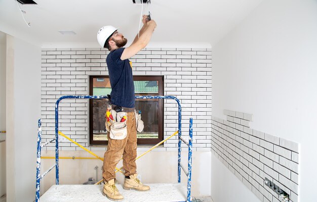 Profesional en monos con herramientas en el sitio de reparación. Concepto de renovación del hogar.