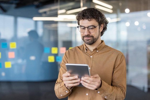 Profesional de negocios que utiliza tableta en la oficina moderna