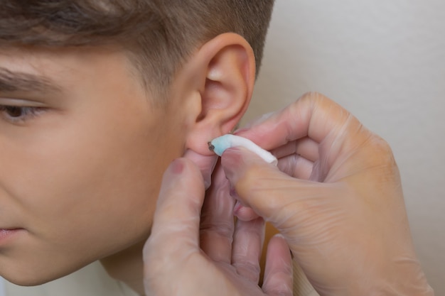 Profesional sosteniendo la joya del piercing justo antes de atornillar la bola