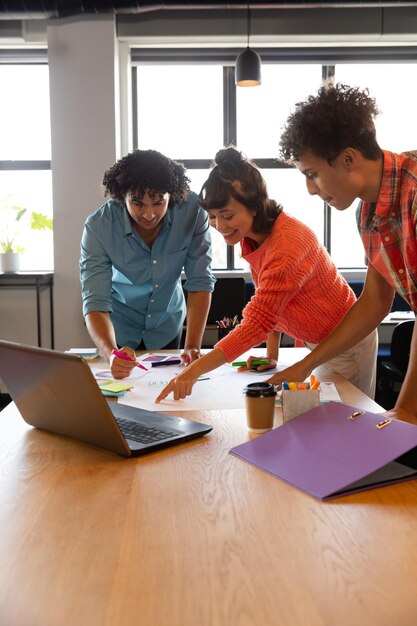 Profesionales creativos del diseño multirracial que planifican estrategias en la mesa de la oficina