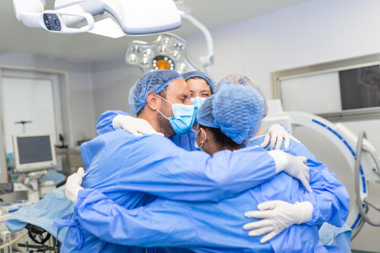 Los profesionales médicos se abrazan en la UCI Los médicos y las enfermeras están en trajes de protección después de un tratamiento exitoso Están en el hospital durante COVID-19
