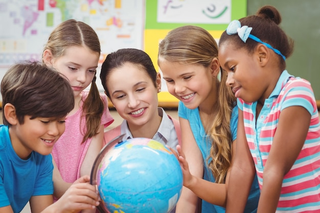 Profesor y alumnos mirando mundo