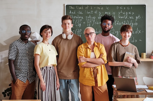 Profesor con alumnos de pie en el aula.