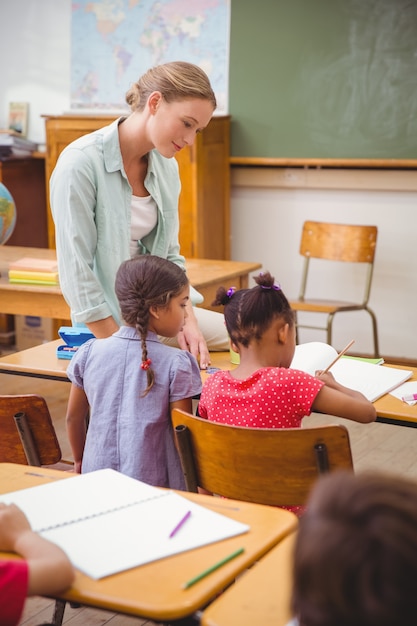 Profesor y alumnos trabajando juntos en el escritorio