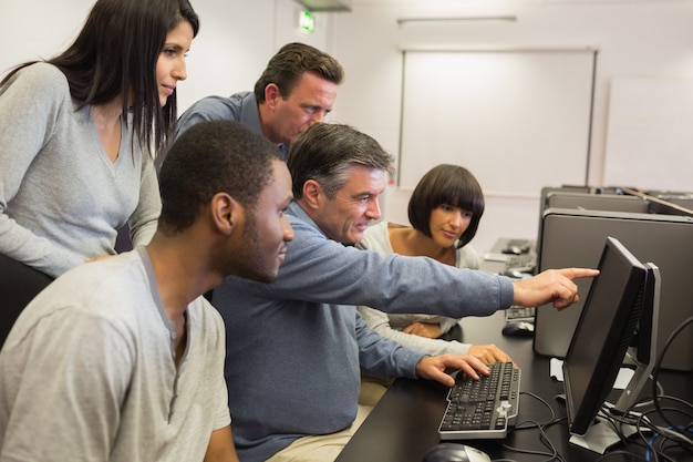 Profesor apuntando al monitor de la computadora