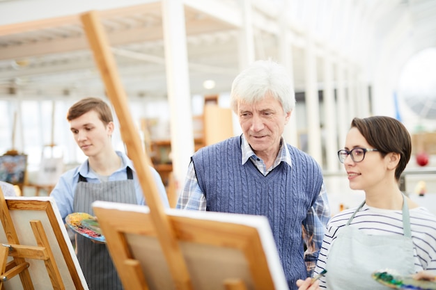 Foto profesor de arte ayudando a estudiantes